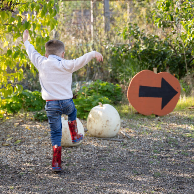 A child in wellies doing a spooky walk to the Pumpkin Patch